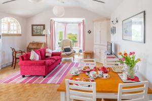 a living room with a table and a pink couch at Ballygate Stable in Beccles +17 photos