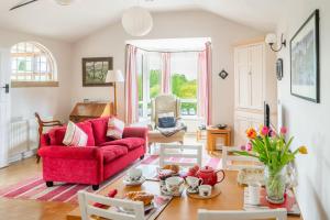 a living room with a red couch and a table at Ballygate Stable in Beccles