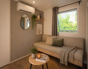 a small living room with a couch and a window at Camping Cabestan in Bretignolles-sur-Mer