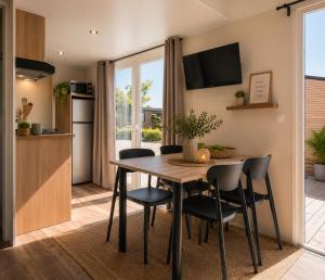 a kitchen and dining room with a table and chairs at Camping Cabestan in Bretignolles-sur-Mer +33 photos