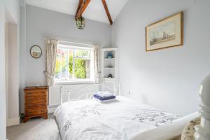 a bedroom with a white bed and a window at Ballygate Stable in Beccles