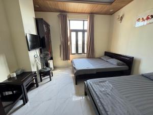 a hotel room with two beds and a window at Phương Nhi Motel in Danang