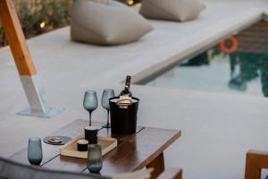 a table with a bottle of wine and glasses on it at Villa Sunrise by the Sea in Kiotari