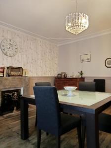 a dining room with a table and chairs and a clock at La maison de Thiré in Thiré