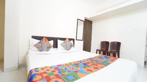 a bedroom with a large bed with a colorful comforter at Peelamedu PSG Tech Near Rooms in Coimbatore