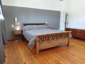 a bedroom with a bed and a wooden floor at Temporario Avenida in Rafaela