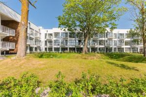 an apartment building with trees in front of it at Baltic Porto M66 in Gdańsk