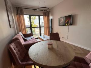 a living room with a wooden table and chairs at Baltic Porto M66 in Gdańsk