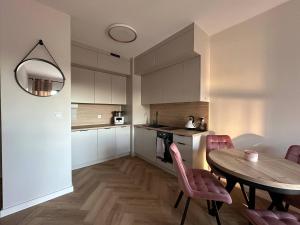 a kitchen and dining room with a table and chairs at Baltic Porto M66 in Gdańsk