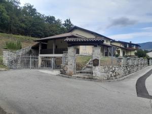 a house with a stone fence in front of a road at Apartma Pri Stevotu in Deskle