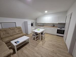a living room with a couch and a table at Apartma Pri Stevotu in Deskle