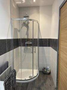 a shower in a bathroom with black and white tiles at 19a Francis Street in Stornoway +26 photos