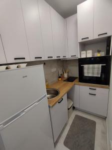 a white kitchen with a sink and a refrigerator at Apartman Limski Kutak in Železnička Stanica Prijepolje