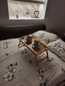 a coffee table with two cups on a bed at Apartman Limski Kutak in Železnička Stanica Prijepolje