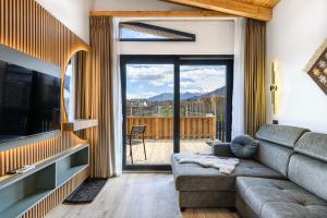 a living room with a couch and a large window at Selva Cabins in Zărneşti