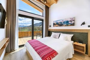 a bedroom with a large bed and a large window at Selva Cabins in Zărneşti