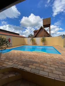 ein Swimmingpool in einem Hof mit einem Gebäude in der Unterkunft Cantinho Rústico Brotas SP + Piscina Privativa + Ar Condicionado in Brotas