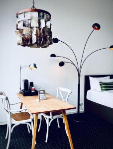 a bedroom with a table and a bed and a lamp at Aparthotel Flughafen Leipzig in Freiroda