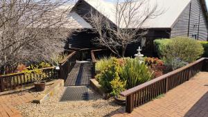 a house with a wooden fence and some plants at Khumbula Lodge in Underberg