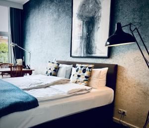 a bed with pillows and a lamp in a bedroom at Aparthotel Flughafen Leipzig in Freiroda