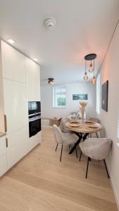 a kitchen and dining room with a table and chairs at Apartamentai Trakų centre in Trakai