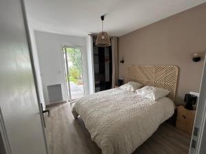 a bedroom with a bed and a large window at Maison moderne avec piscine in La Teste-de-Buch +19 photos