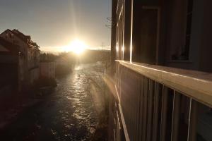 a sun setting over a river with a building at Flusshaus BnB Alicudi in Brugg