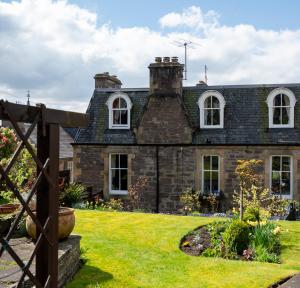 an old stone house with a garden in front of it at Leven House Bed and Breakfast in Crieff