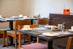 a dining room with tables and chairs with dishes on them at Leven House Bed and Breakfast in Crieff
