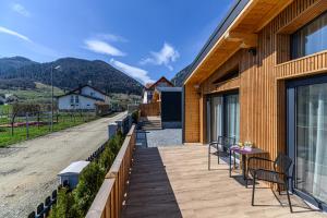 a patio with chairs and a table on a building at Selva Cabins in Zărneşti