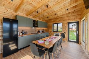 a kitchen and dining room with a table and chairs at Selva Cabins in Zărneşti