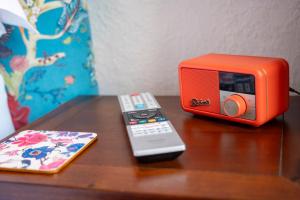 an orange radio and a remote control on a table at Leven House Bed and Breakfast in Crieff