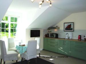 a kitchen with a table and white chairs and a sink at Glendalough Scenery Farmhouse in Roundwood