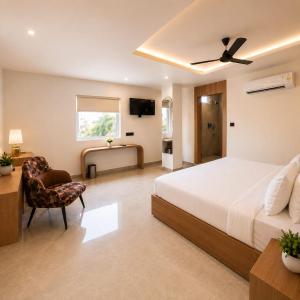 a bedroom with a bed and a desk and a chair at Velara Hotel & Banquet in Gwalior