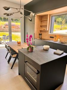 a kitchen with a large island with a table at Ty Toralann in Guipavas +3 photos