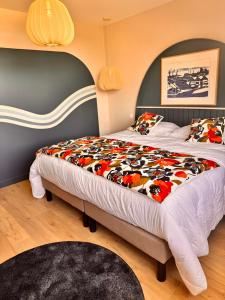 a bedroom with a large bed with a colorful blanket at Ty Toralann in Guipavas