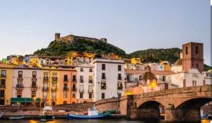 a view of a city with a bridge and buildings at Astrolicamus, Intero Alloggio con camera e bagno in Bosa