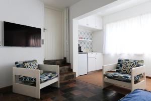 a living room with two chairs and a flat screen tv at Seaward Studio Suite in Ramsgate +8 photos