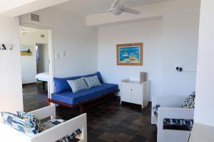 a living room with a blue couch and a bed at Seaward Studio Suite in Ramsgate