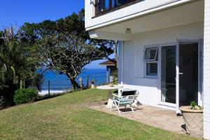 a white house with a table and a chair at Seaward Studio Suite in Ramsgate