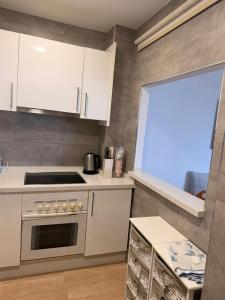 a kitchen with white cabinets and a stove top oven at andaluz in La Mamola