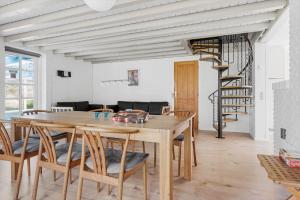 a dining room with a wooden table and chairs at 2808-Romo-Lejrbjergvej-4 in Høm