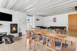 a living room with a table and a fireplace at 2808-Romo-Lejrbjergvej-4 in Høm