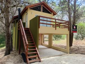 a house with a staircase leading up to it at Bosque y Mar in Mar Azul