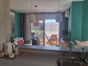 a kitchen with a view of a living room with a couch at Albir Sunshine Apartments in Albir