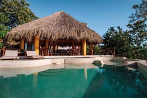 a hut with chairs and a swimming pool at Hotel Ruunda in San Agustinillo +82 photos