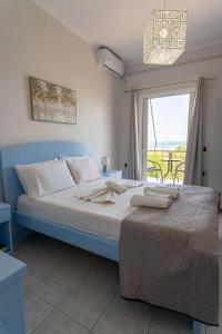 a bedroom with a large bed with a large window at Laloudaki Apartments in Tyros