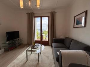 a living room with a couch and a glass table at St Guenole' Studio Apartment in Landévennec