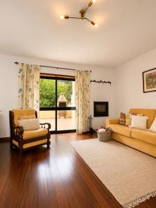 a living room with a couch and a chair at Refúgio do Vidoeiro in Geres