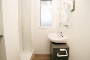 a white bathroom with a sink and a mirror at Safari Beach & Camping in Donji Štoj +37 photos